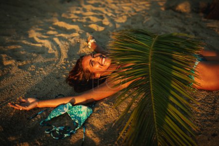 Téléchargez les photos : Portrait de belle jeune femme sur la plage pendant ses vacances - en image libre de droit
