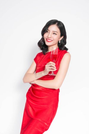 Téléchargez les photos : "Belle fille asiatique en robe de soirée souriante tenant verre de champagne" - en image libre de droit