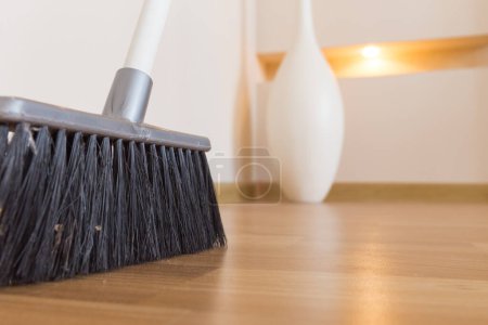 Photo for Broom on wooden floor close up - Royalty Free Image