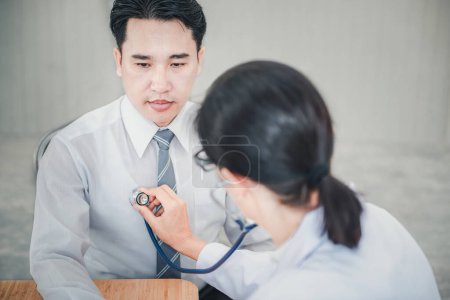 Photo for "Medical Doctor is Examining Patient Health With Stethoscope in Hospital Examination Room, Female Physician Doctor is Diagnosing Physical Health Check Up for Male Patient. Medicine/Healthcare Concept" - Royalty Free Image