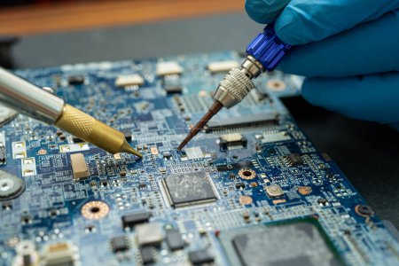 Téléchargez les photos : "Réparation à l'intérieur du disque dur par le fer à souder. Circuit intégré. le concept de données, matériel, technicien et technologie." - en image libre de droit