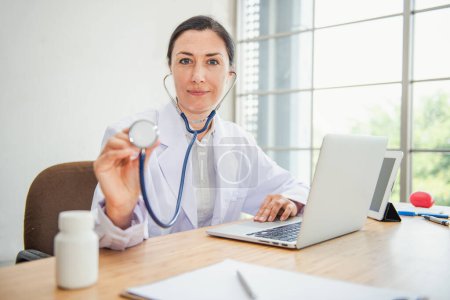 Téléchargez les photos : "Medical Doctor is Examining Patient Health With Stethoscope in Hospital Examination Room, Female Physician Doctor is Diagnosing Physical Health Check Up for Patients. Medicine/Healthcare Concept" - en image libre de droit
