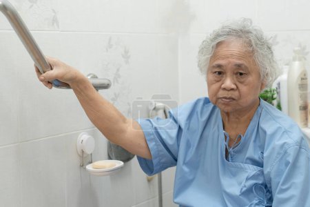 Photo for "Asian senior or elderly old lady woman patient use toilet bathroom handle security in nursing hospital ward, healthy strong medical concept." - Royalty Free Image