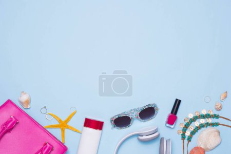 Téléchargez les photos : "Concept d'été. Sac à main rose avec accessoires sur fond bleu clair
" - en image libre de droit