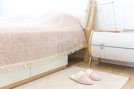 Photo for Bedroom in modern style with pink cozy soft slippers on floor - Royalty Free Image