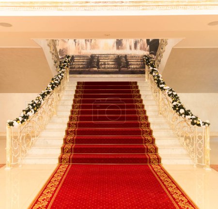 Téléchargez les photos : Hall avec escalier rouge décoré de fleurs - en image libre de droit