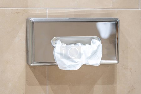Téléchargez les photos : Distributeur de serviettes en papier sur le mur dans la salle de bain - en image libre de droit