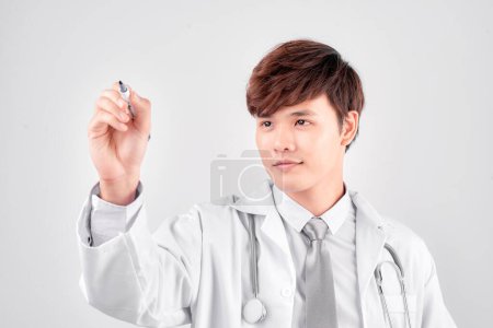 Photo for Asian medical doctor write on imaginary panel - Royalty Free Image