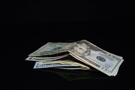 Téléchargez les photos : Dollars isolés sur fond noir - en image libre de droit