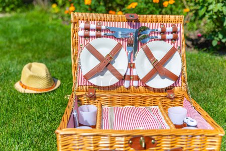 Photo for "Picnic basket on green sunny lawn in the park" - Royalty Free Image