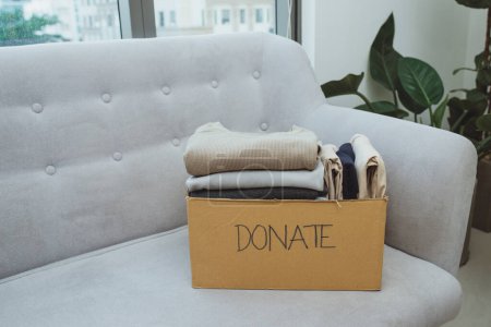 Téléchargez les photos : "vêtements dans la boîte pour le don de concept et la réutilisation recycler
" - en image libre de droit