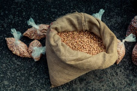 Photo for Unshelled peanuts in a straw sack on display - Royalty Free Image