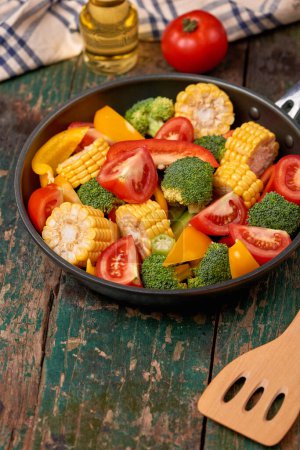 Photo for "Fresh fruits and vegetables on a frying pan on an old wood background" - Royalty Free Image