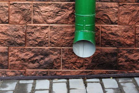 Photo for "Water Draining Gutter Downpipe on a brown wall" - Royalty Free Image