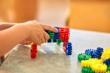 Foto de "Un niño recoge un rompecabezas suave en la mesa. Niños preescolares y juguetes educativos" - Imagen libre de derechos