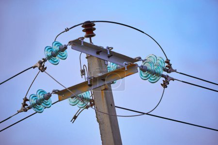 Foto de "La parte superior del poste eléctrico sobre fondo azul del cielo" - Imagen libre de derechos