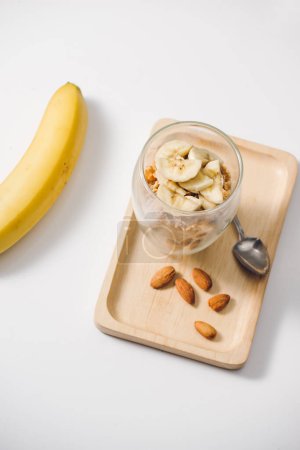 Foto de "Listo para comer sano un desayuno nutritivo granola con almendras, semillas de chía, plátano y kiwi frutas y bayas y un frasco con leche cerca
" - Imagen libre de derechos