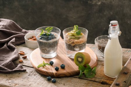Téléchargez les photos : "Petit déjeuner sain - bol de muesli, baies et fruits, noix, kiwi, lait
" - en image libre de droit
