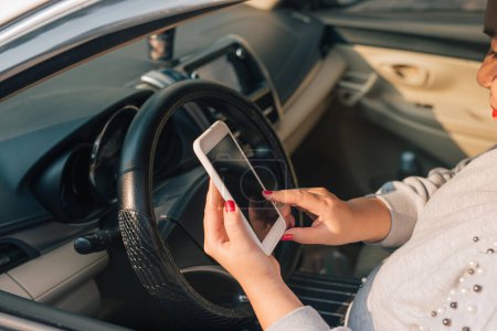 Foto de "Conductor de la mujer que utiliza el teléfono inteligente en el coche durante el atasco de tráfico, pantalla en blanco para el propósito de diseño
 ." - Imagen libre de derechos
