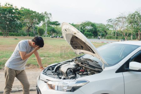 Téléchargez les photos : "jeune homme stressé ayant des problèmes avec sa voiture cassée regardant dans la frustration à moteur en panne" - en image libre de droit