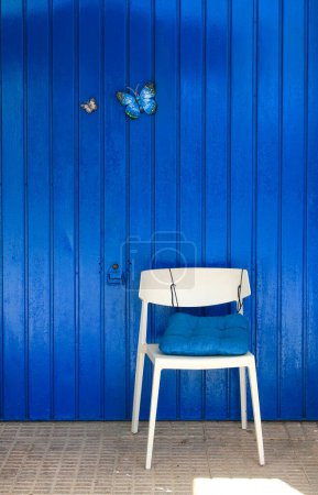 Téléchargez les photos : "Porte métallique bleue colorée avec deux papillons décoratifs" - en image libre de droit