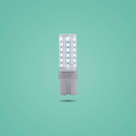 Photo for "LED energy saving lamp 230v in a ceramic socket isolated on green pastel color background." - Royalty Free Image