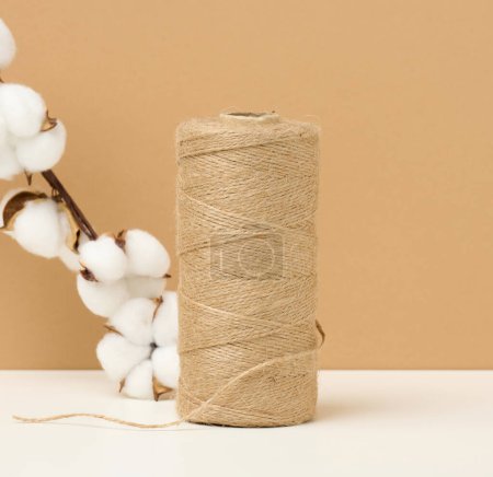 Photo for "reel with brown rope on a white table, packing material" - Royalty Free Image