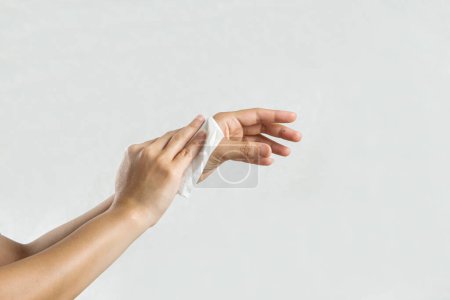 Téléchargez les photos : "Femme se nettoyant les mains avec du papier mouchoir blanc. isolé sur un fond blanc" - en image libre de droit