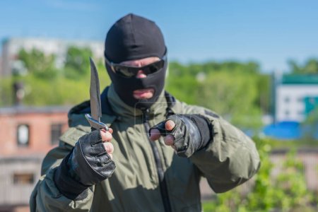 Foto de Bandido de la calle señala a alguien y amenaza con un cuchillo - Imagen libre de derechos