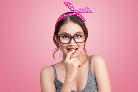 Foto de Retrato de moda de chica asiática con gafas de sol de pie sobre fondo rosa
. - Imagen libre de derechos