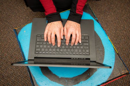 Photo for "View of woman's hands typing on a black keyboard laptop." - Royalty Free Image