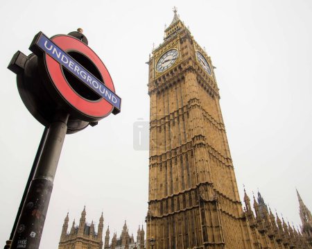 Photo for "Juxtaposition of an Underground sign with the Big Ben clock tower. Unique perspective" - Royalty Free Image