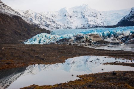 Téléchargez les photos : "Glacier islandais bleu vif avec des couches de glacier, de cendres volcaniques, de neige et d'eau fondue." - en image libre de droit