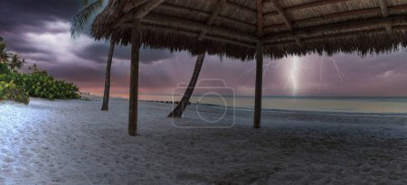 Photo for "Lightning storm over a tiki at the ocean at Port Royal Beach" - Royalty Free Image