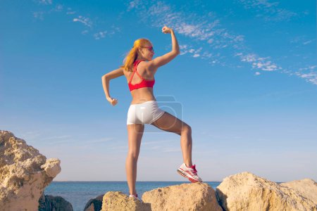 Photo for Young fitness woman on rock - Royalty Free Image