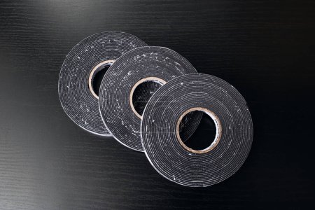 Photo for Three reels of double-sided tape on wooden table - Royalty Free Image
