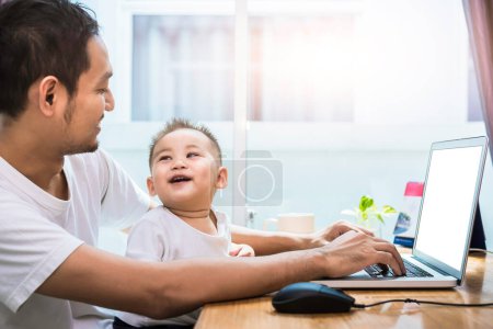 Photo for Single dad and son using laptop together happily. Technology and Lifestyles concept. Happy family and baby theme. - Royalty Free Image