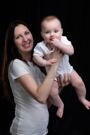 Photo for Mom and little son on a dark background. Motherhood. - Royalty Free Image
