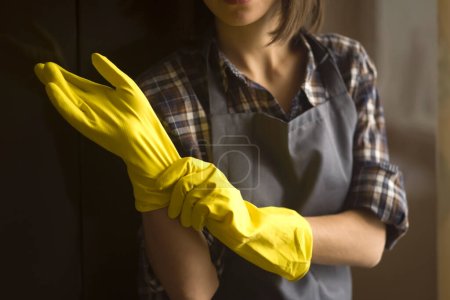 Téléchargez les photos : Une femme en gants de caoutchouc jaune fait le ménage - en image libre de droit
