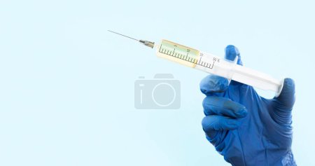 Photo for Hand with latex glove holding syringe - Royalty Free Image