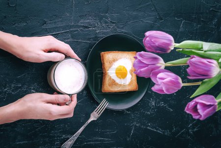 Téléchargez les photos : "Toujours le petit déjeuner pour un être cher avec tulipes sur fond sombre" - en image libre de droit