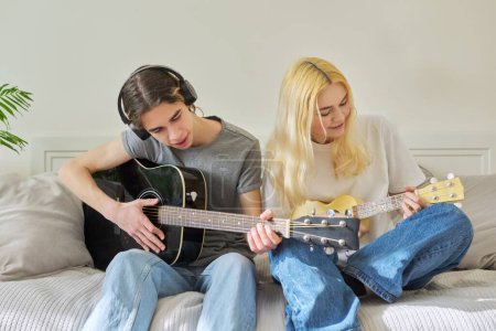 Téléchargez les photos : "Amis adolescents créatifs avec instruments de musique, guitare acoustique et ukulélé" - en image libre de droit
