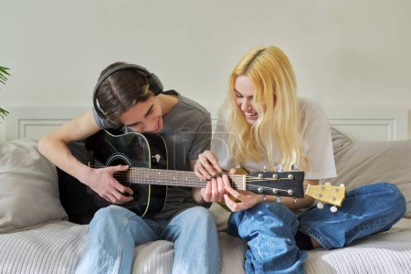 Téléchargez les photos : "Amis adolescents créatifs avec instruments de musique, guitare acoustique et ukulélé" - en image libre de droit