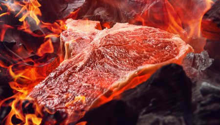 Téléchargez les photos : "steak de bœuf marbré cru aux charbons et à la fumée" - en image libre de droit