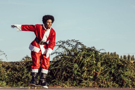 Photo for "Happy african santa claus skateboarding" - Royalty Free Image