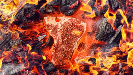 Foto de "raw marbled beef steak with coals and smoke" - Imagen libre de derechos