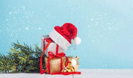 Téléchargez les photos : "boîtes avec cadeaux de Noël avec chapeau de Père Noël sur le dessus." - en image libre de droit