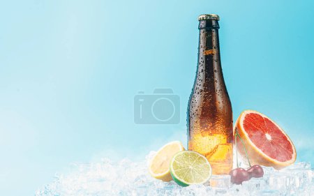 Photo for Closed bottle of brown glass beer on ice. fruits lie nearby. concept of fruit craft beer or cider - Royalty Free Image