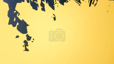 Foto de La pintura abstracta negra salpica goteando sobre un fondo amarillo brillante. La pintura negra salpica sobre un fondo amarillo. concepto de ideas de arte. Pincel textura amarillo y negro sobre fondo - Imagen libre de derechos