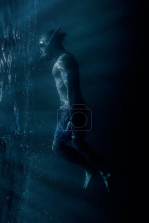 Téléchargez les photos : Homme plongeur libre nageant sous l'eau près de la surface
. - en image libre de droit